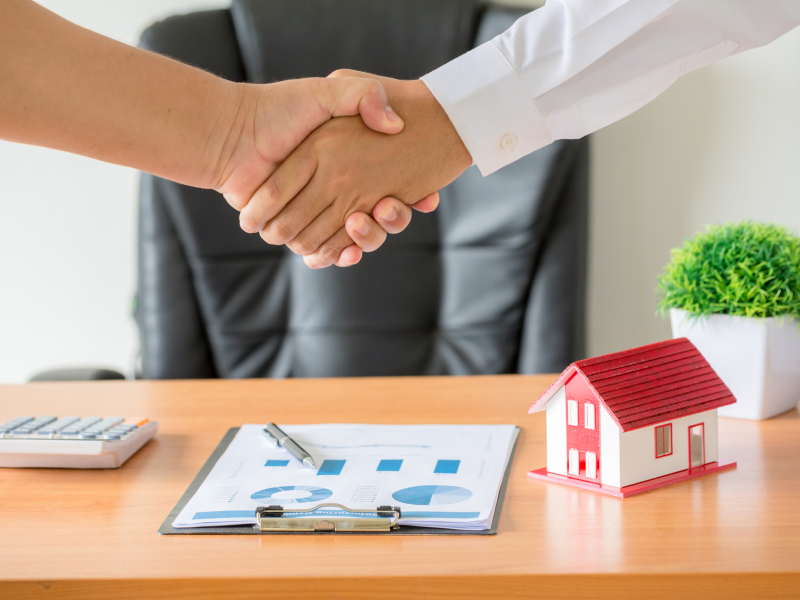 hands of agent and client shaking hands after signed contract bu Side view hands of agent and client shaking hands after signed contract buy new apartment.